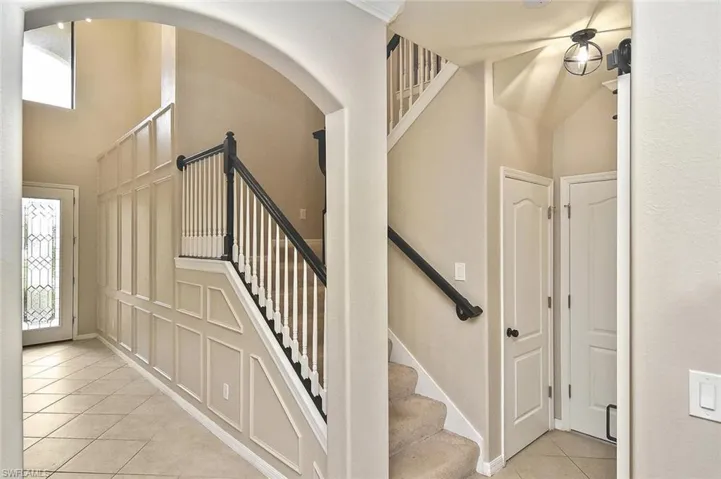 Stairs featuring tile patterned flooring and a towering ceiling