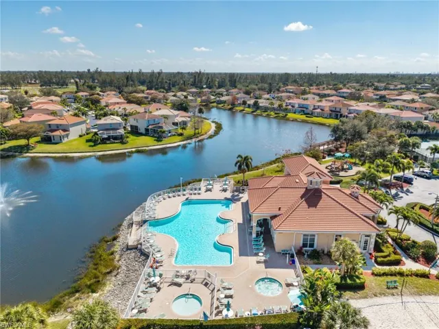 Aerial view of residential area featuring a pool area and a large body of water