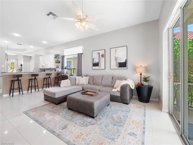 Living area with a ceiling fan and light tile patterned floors