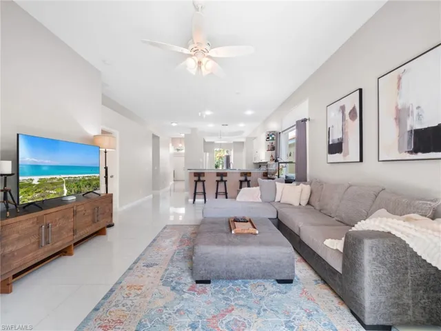 Living area with ceiling fan and light tile patterned floors