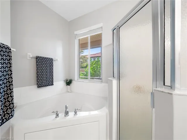 Bathroom featuring a stall shower and a garden tub