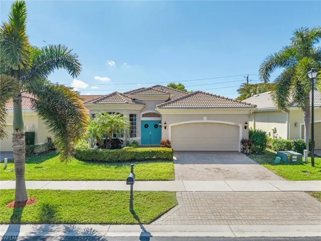 Mediterranean / spanish-style home featuring stucco siding, decorative driveway, a front lawn, an attached garage, and a tiled roof
