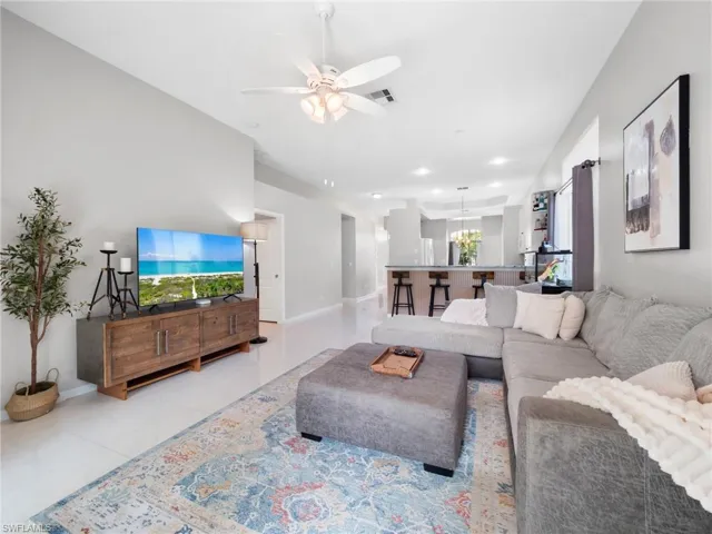Living area featuring ceiling fan and tile patterned floors