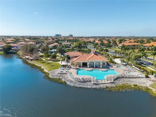 Aerial view of residential area with a pool area and a large body of water