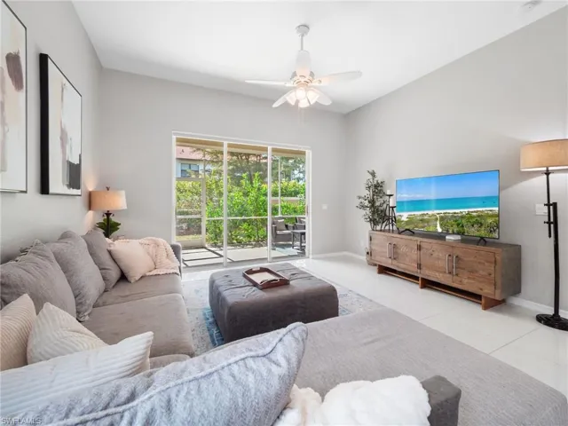 Living area featuring ceiling fan and tile patterned flooring