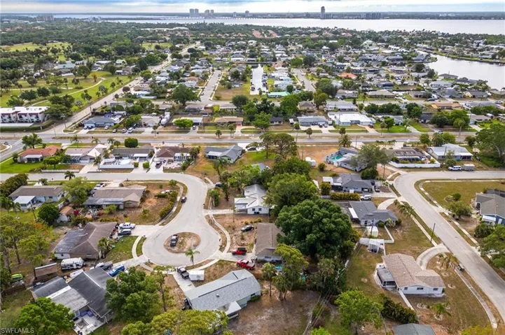 Aerial overview of property's location featuring a large body of water, nearby suburban area, and a notable bridge