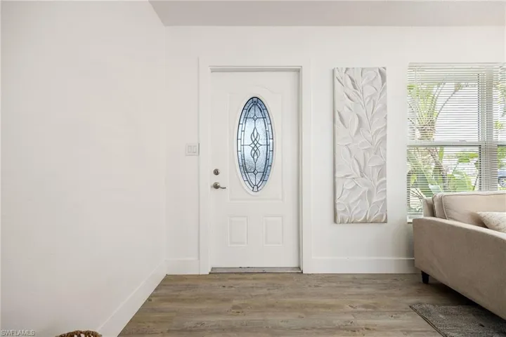 Foyer with baseboards and wood finished floors