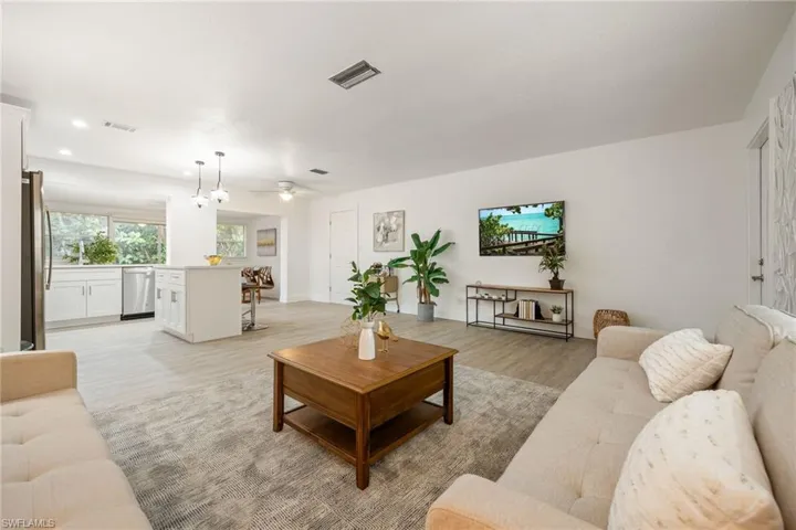 Living area with light wood finished floors, recessed lighting, and a ceiling fan
