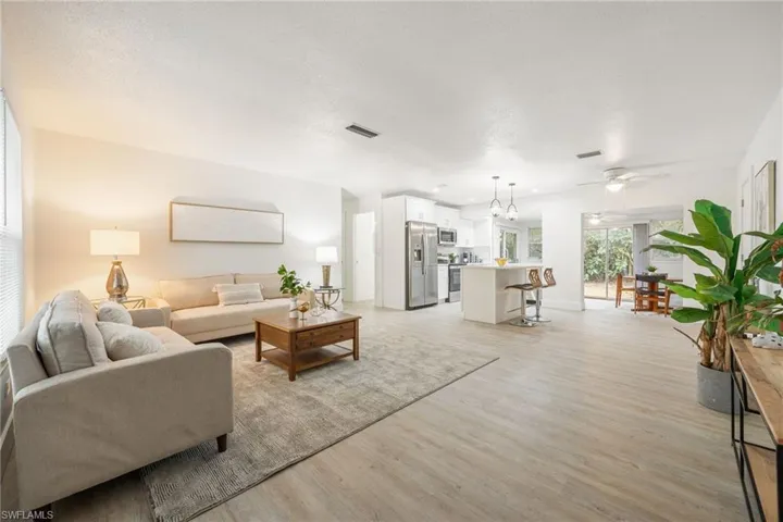Living area featuring light wood-type flooring, a ceiling fan, and baseboards