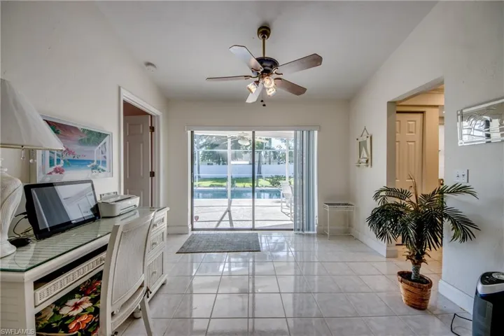 Doorway with a ceiling fan and baseboards