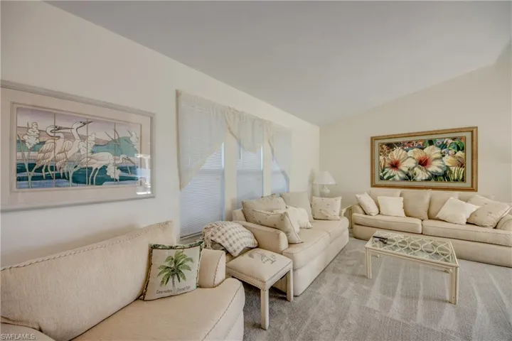 Living area featuring lofted ceiling and carpet floors