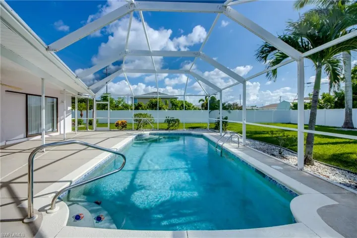 View of pool with a patio, a fenced backyard, and glass enclosure