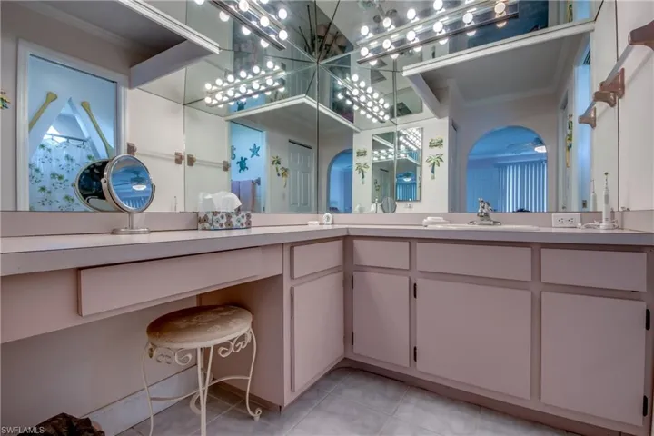 Bathroom with crown molding, tile patterned floors, and double vanity
