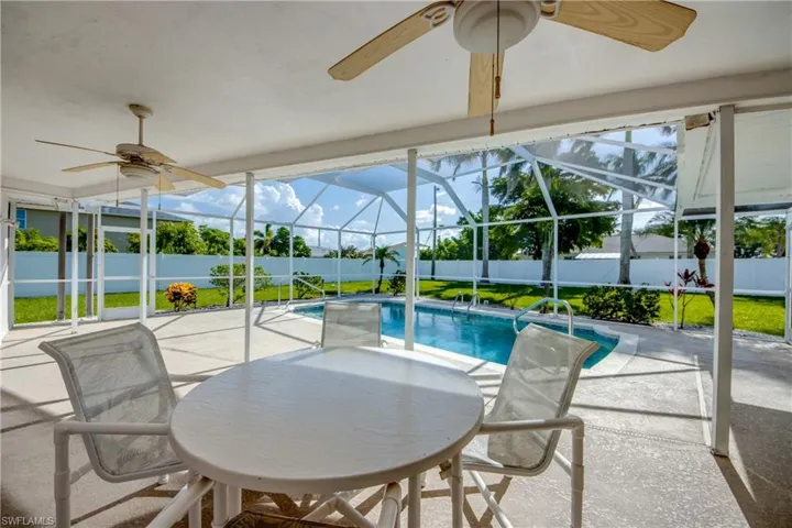 Sunroom featuring a ceiling fan and a swimming pool