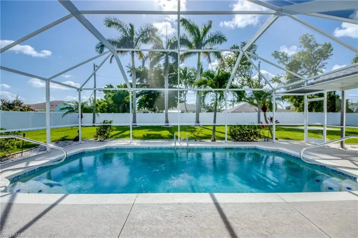 View of pool featuring a fenced backyard, glass enclosure, and a patio area