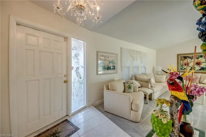 Entrance foyer with vaulted ceiling, a chandelier, and light tile patterned flooring