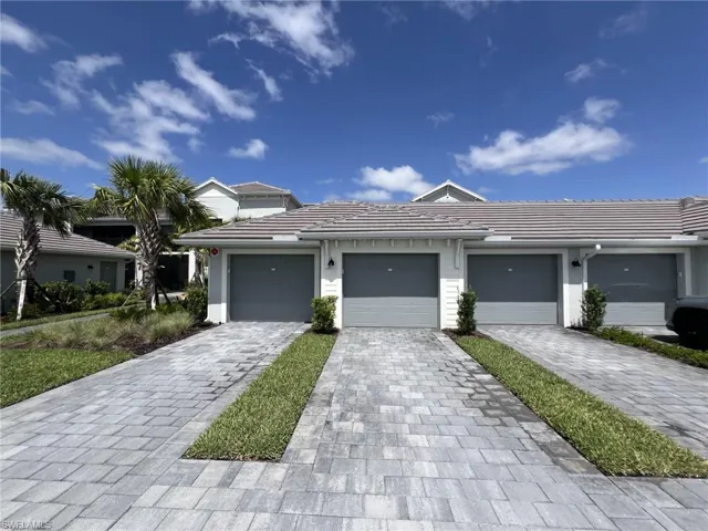 Prairie-style home featuring decorative driveway and a tiled roof