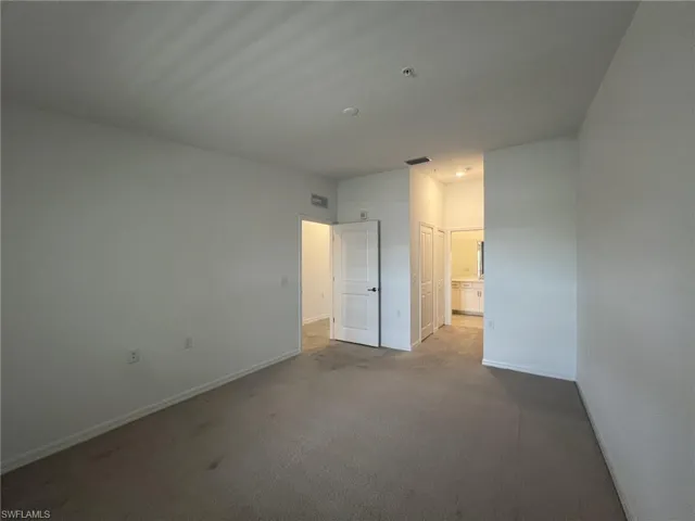 Primary bedroom featuring carpet, connected bathroom, and a closet