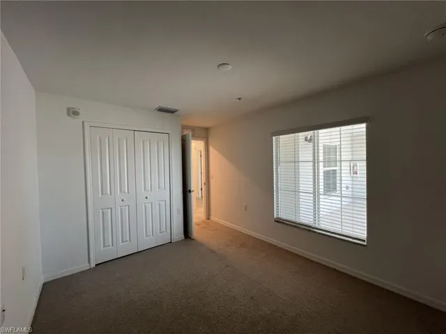 Unfurnished bedroom with carpet and a closet