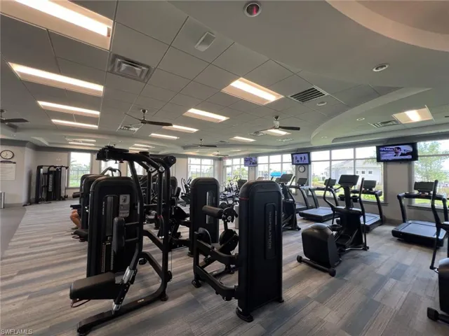 Workout area with a paneled ceiling and baseboards