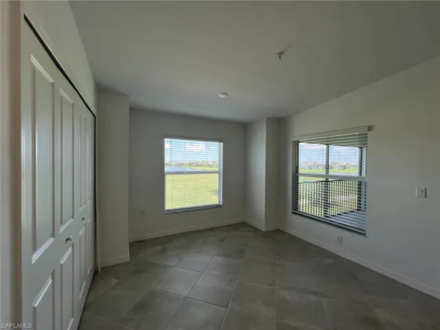 Dining area with multiple windows, a closet, and light tile patterned flooring