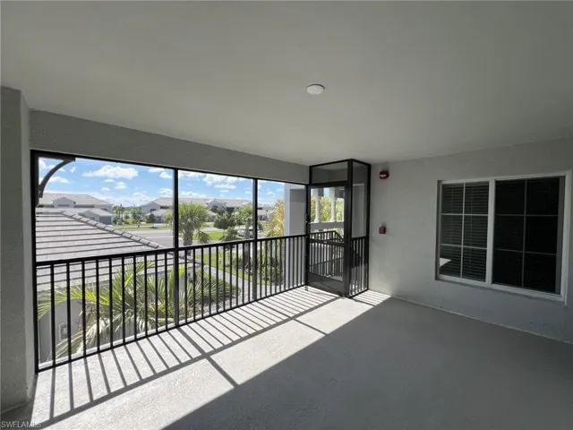 Unfurnished sunroom with a textured wall and a residential view