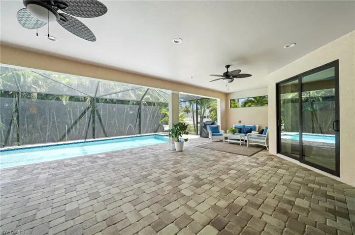 Swimming pool with a ceiling fan, a patio area, a lanai, and outdoor lounge area