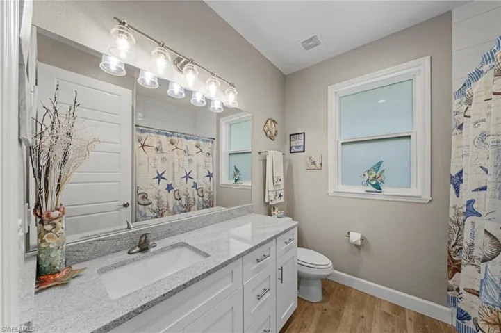 Bedroom with carpet floors, connected bathroom, and ceiling fan
