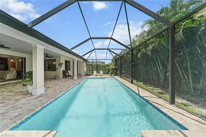 Swimming pool featuring a patio, a ceiling fan, and a lanai