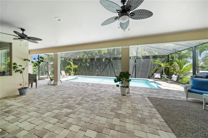 View of pool featuring a ceiling fan, a lanai, and a patio