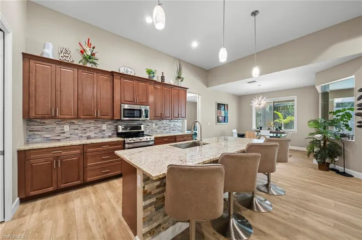 Dining area with light wood-style floors, a chandelier, and a ceiling fan