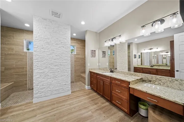 Kitchen featuring appliances with stainless steel finishes, light stone counters, and light wood finished floors
