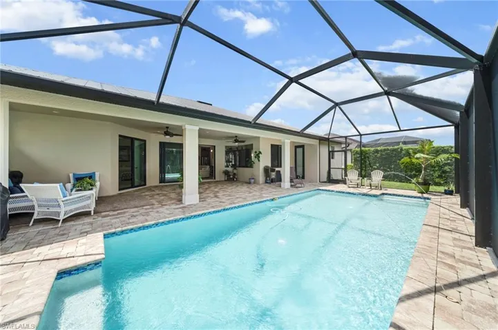 Swimming pool with a patio, a ceiling fan, and glass enclosure