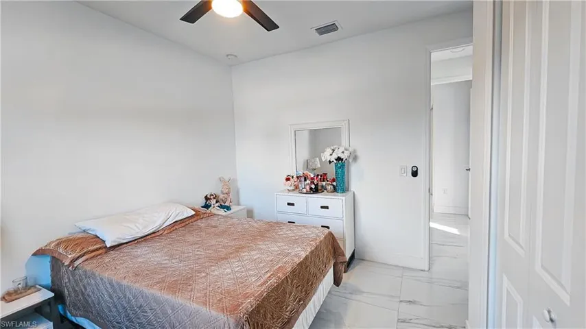 Bedroom with light marble finish flooring and a ceiling fan