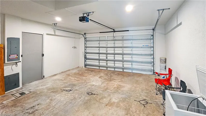 Garage featuring electric panel and a garage door opener