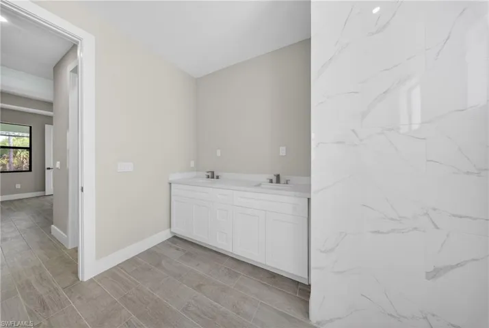 Double vanity with white cabinetry, integrated sinks, and polished chrome faucets