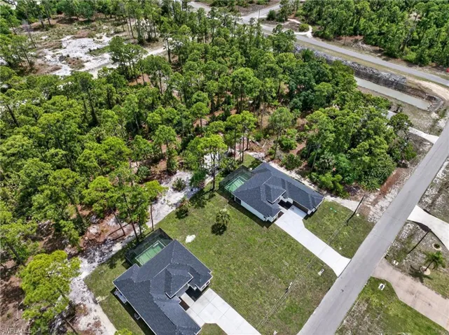 New construction homes featuring dark shingle roofing, concrete driveways, and green lawns