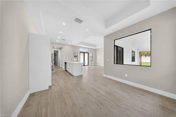 Open-concept living space with wood-finish tile flooring and recessed lighting