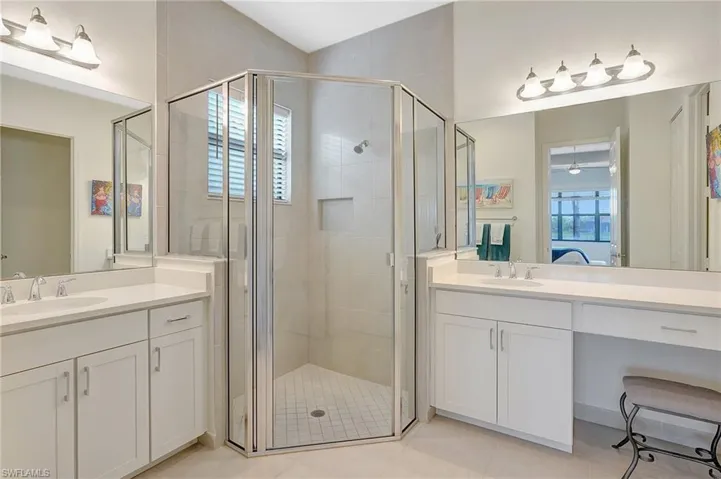 Bathroom with an enclosed shower, tile patterned flooring, and a wealth of natural light