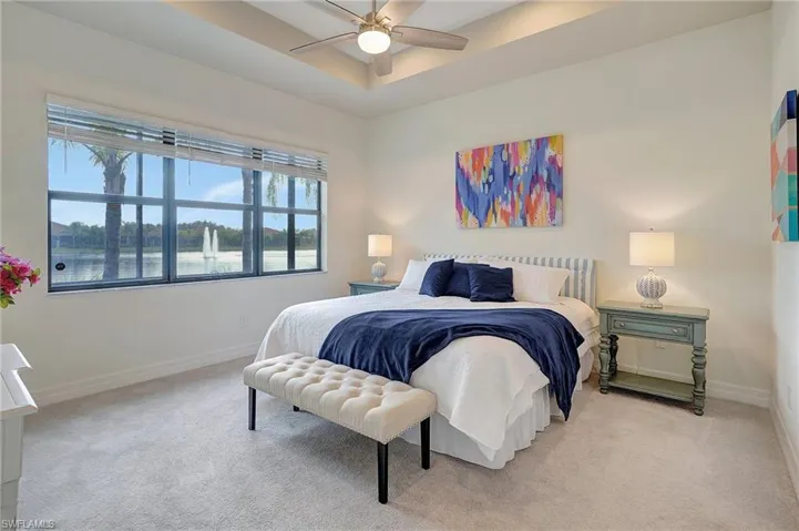 Bedroom with multiple windows, light carpet, and ceiling fan