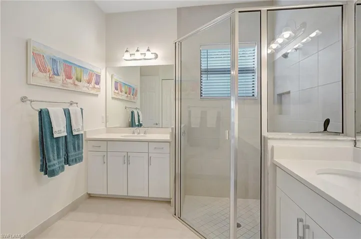 Bathroom featuring vanity, tile patterned floors, and an enclosed shower