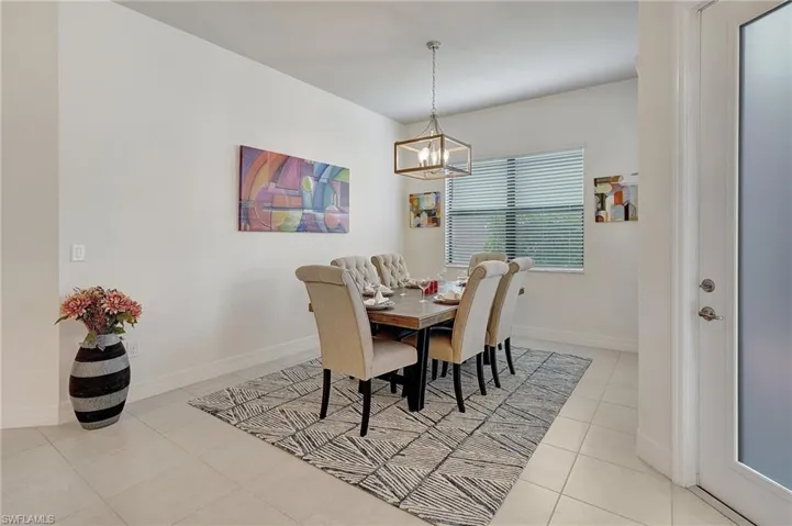 Dining room with light tile patterned flooring and a notable chandelier