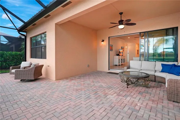 View of patio with glass enclosure, ceiling fan, and an outdoor hangout area