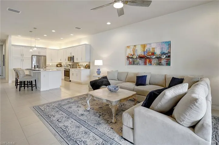 Living room with ceiling fan, sink, and light tile patterned floors