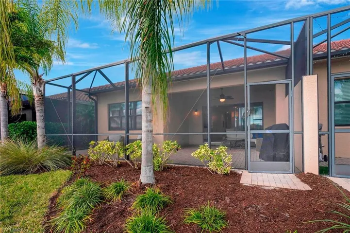 Rear view of house featuring glass enclosure and ceiling fan