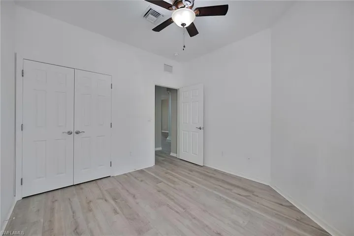 Unfurnished bedroom featuring ceiling fan, light wood finished floors, and a closet