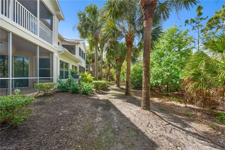 View of yard featuring a sunroom and a balcony