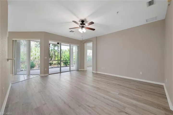 Spacious Living room with a ceiling fan and light wood finished floors