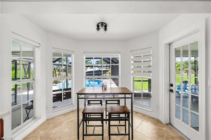 Dining space with light tile patterned floors and a water view