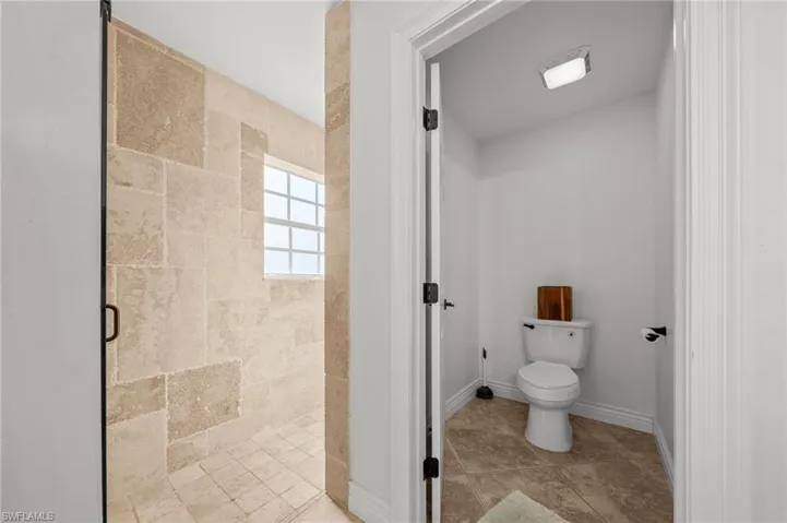 Bathroom featuring a shower stall and toilet